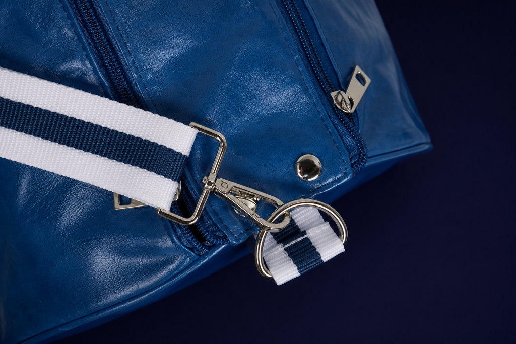 Close-up of Neptune blue duffle bag zipper, silver hardware and shoulder strap